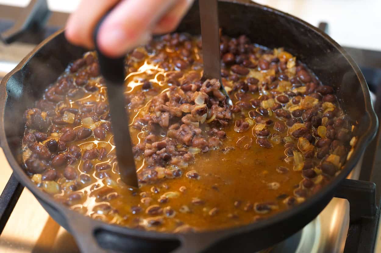 Mashing black beans in a skillet for refried black beans