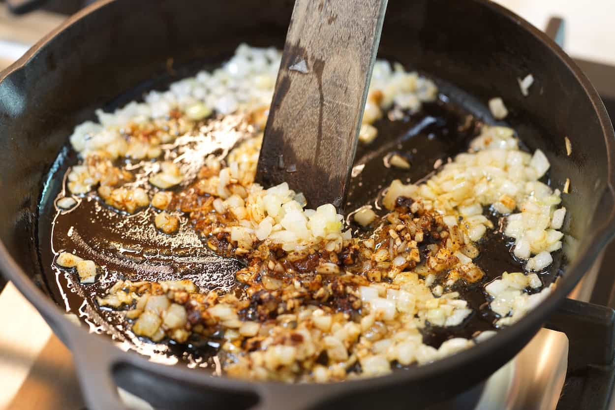 Toasting spices and garlic with sautéed onion in a skillet