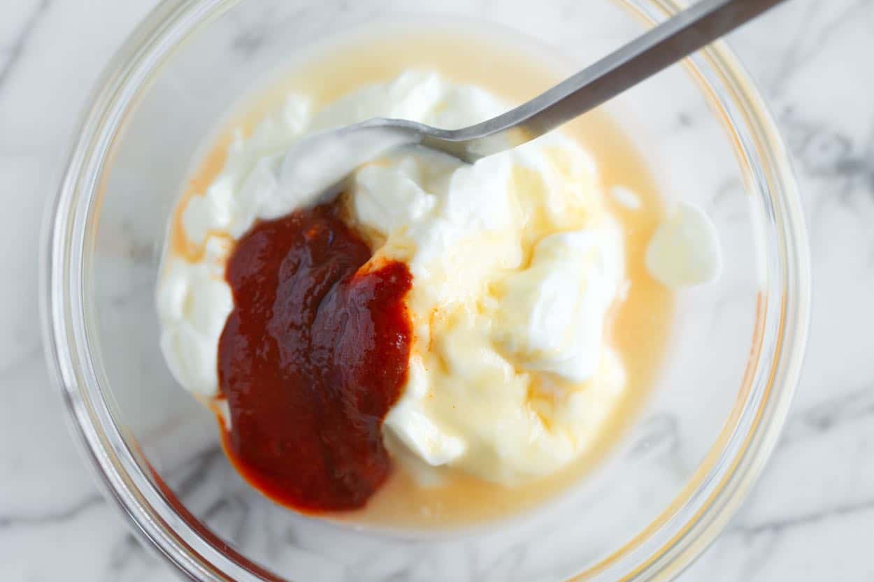 gochujang yogurt sauce ingredients in a bowl ready for topping pork burgers