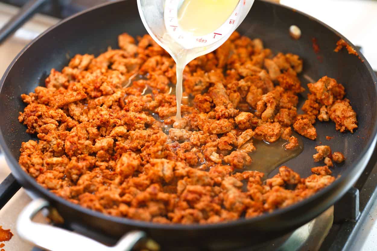 Pylimas vištienos sultinio į keptuvę su taco mėsa tostados gaminimui