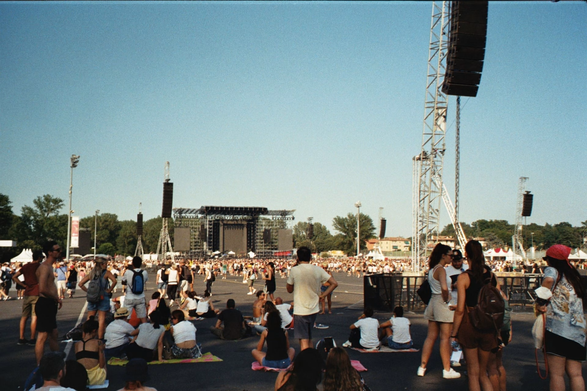 Crowd enjoying a summer music festival outdoors on a sunny day.
