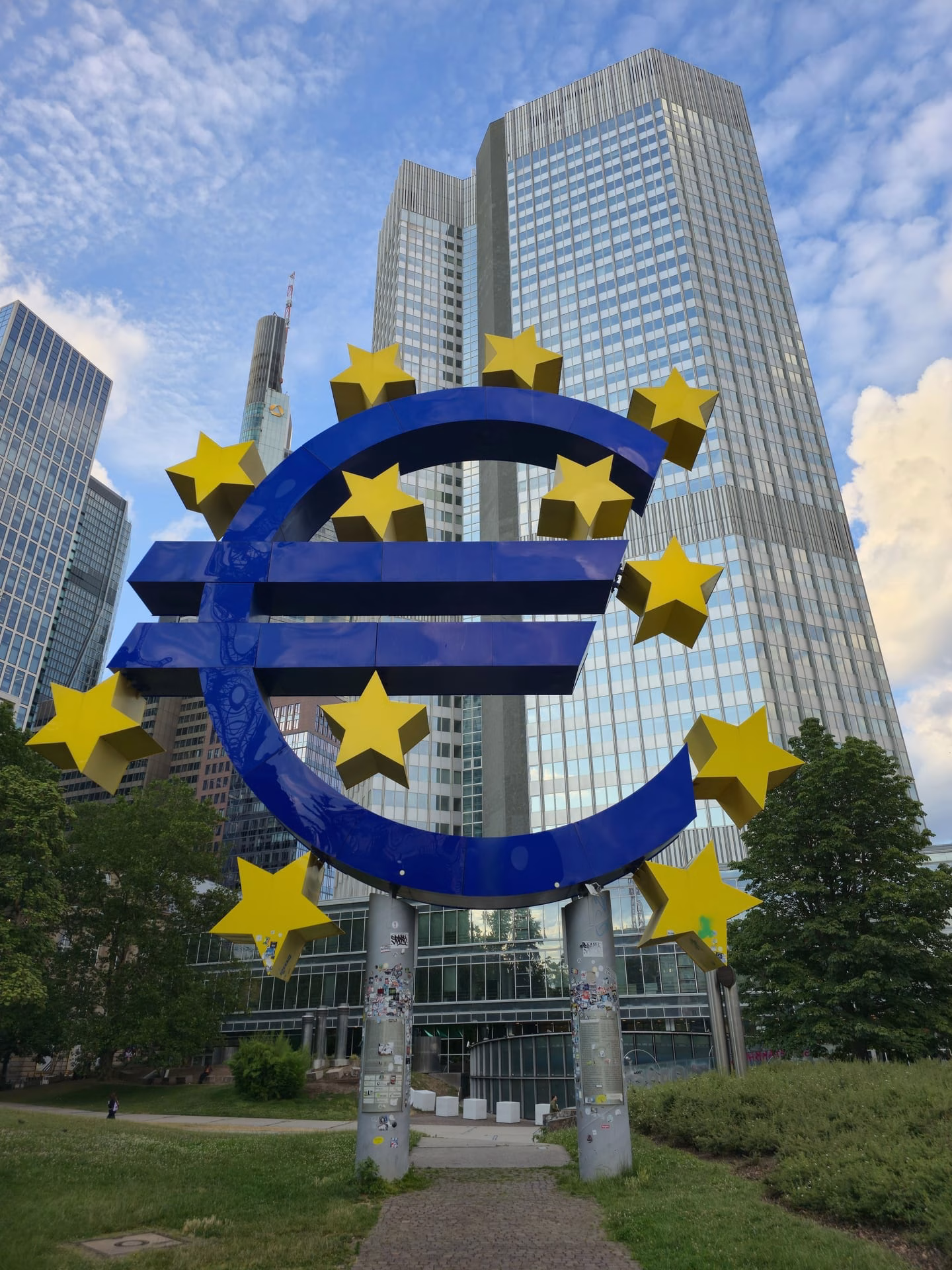 The Euro sculpture stands tall amid Frankfurt's modern skyscrapers, symbolizing financial strength.
