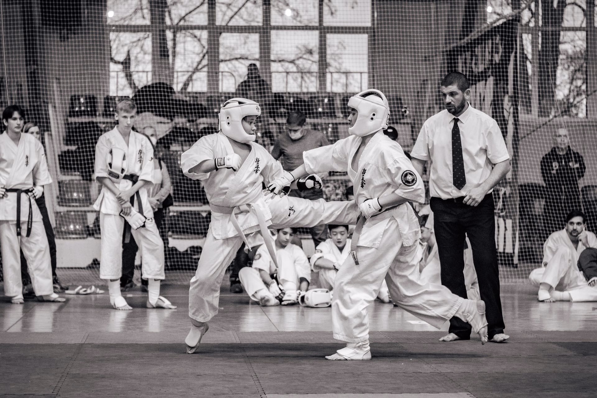 Two martial artists compete in a thrilling karate match during a tournament, showcasing intense focus and skill.