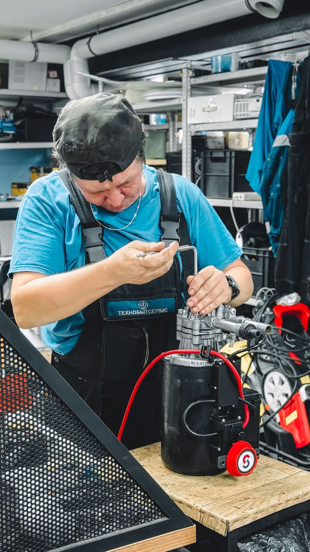 Mechanic working on machinery in a busy workshop setting, showcasing industrial repair skills.