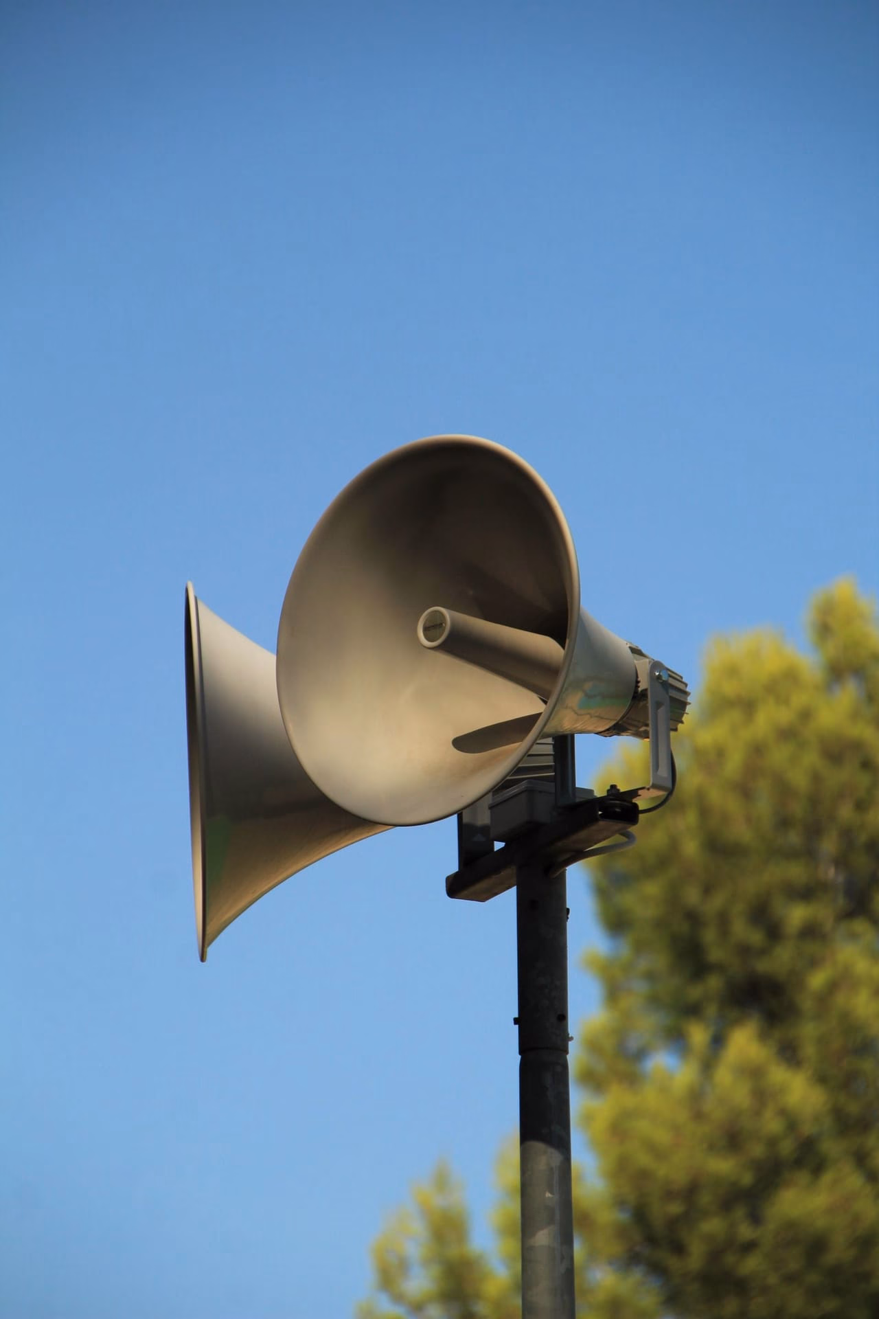 Outdoor megaphone against a clear blue sky for public announcements.