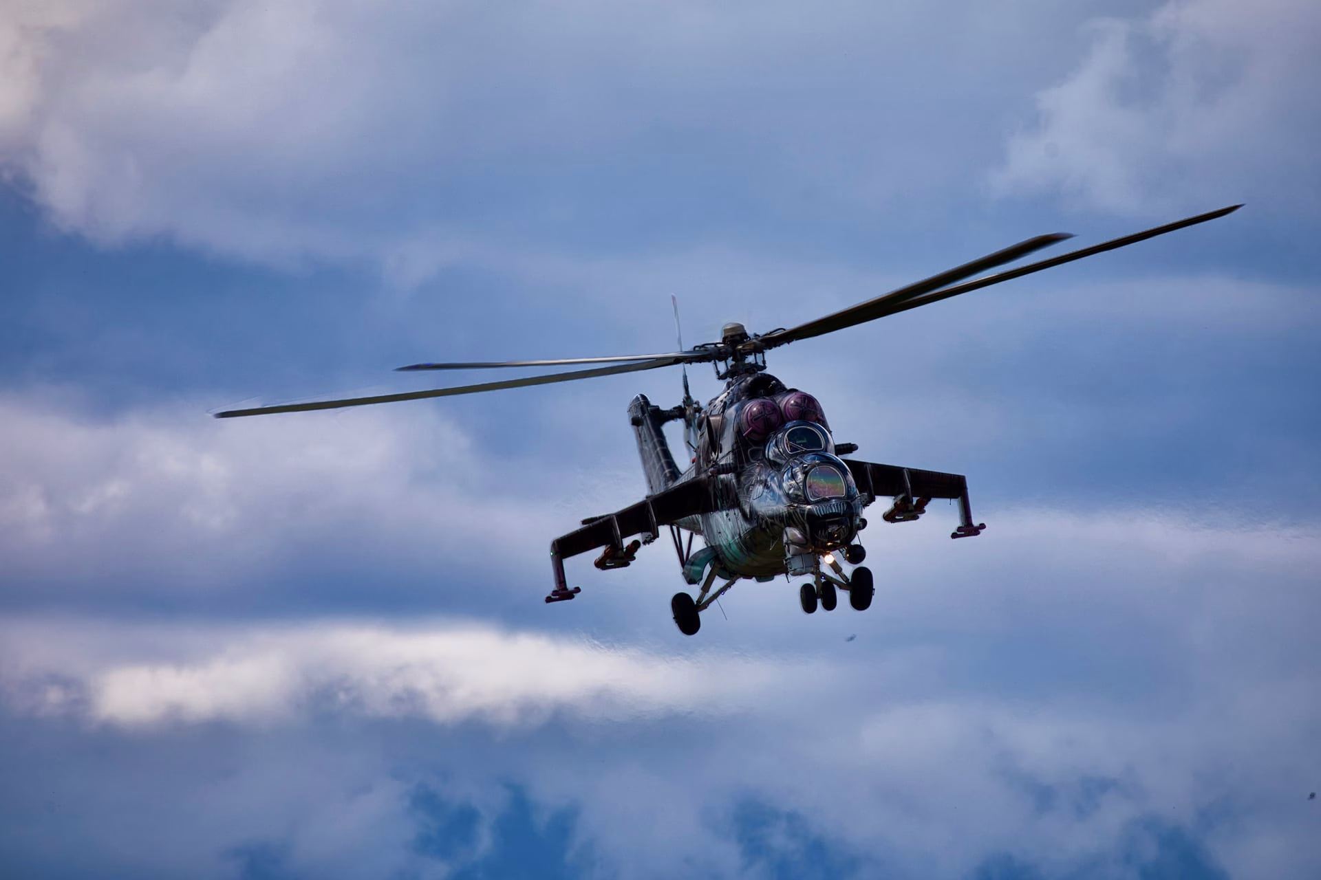 A military helicopter soaring through the cloudy sky, showcasing its power and technology.