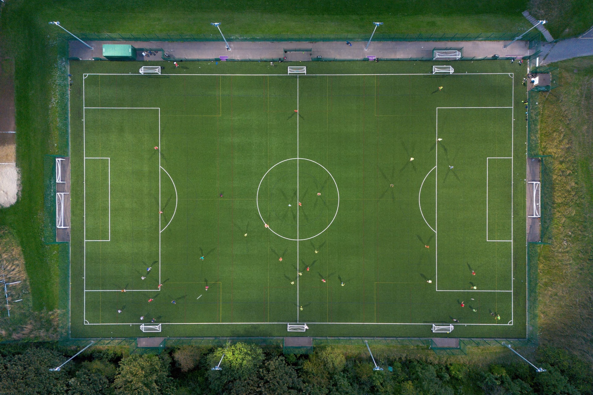 Top-down shot of a soccer match on a green field in Brighton, UK.